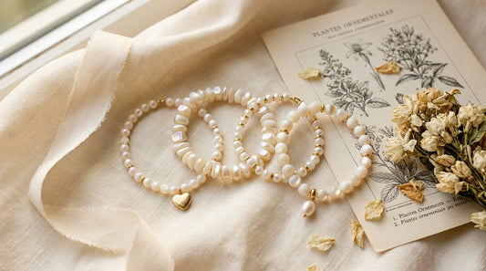 Collection de bracelets en nacre aux reflets irisés sur tissu crème