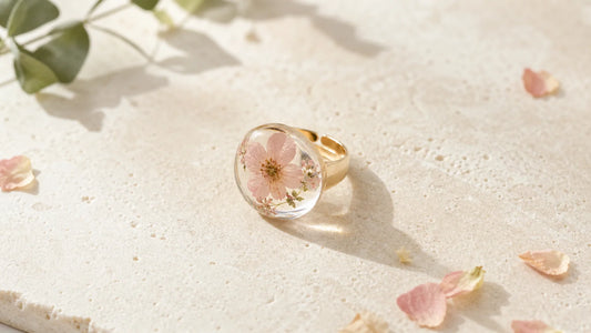 Bijou en résine avec fleur séchée sur une surface naturelle